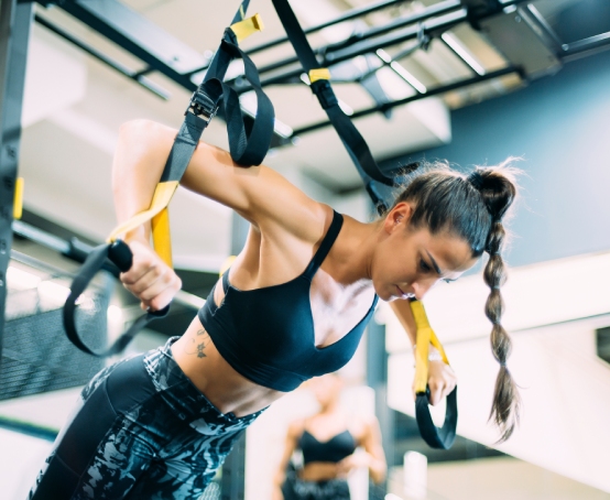 Femme s'entraînant avec TRX
